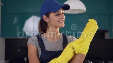 美丽的微笑女人从清洁服务，戴着防护手套清洁<strong>蓝黑色</strong>厨房